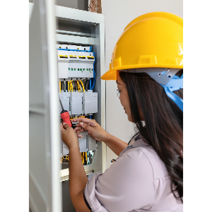 electrician using a screwdriver out some screws in an electrical panel inside a home
